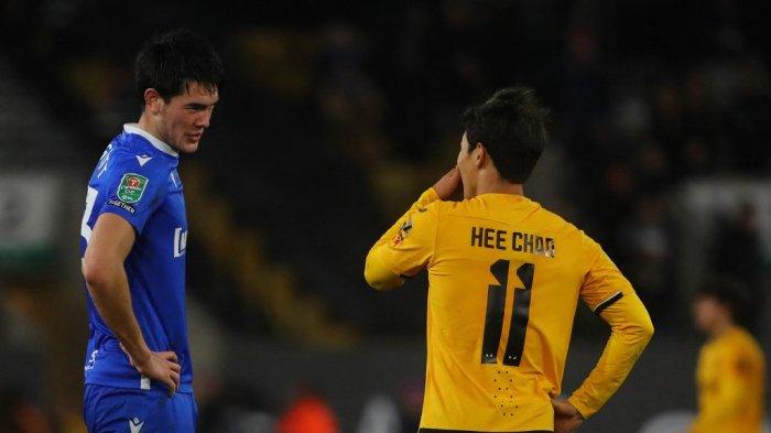 Bek Gillingham asal Indonesia Elkan Baggott (kiri) berbicara dengan striker Wolverhampton Wanderers asal Korea Selatan Hwang Hee-chan setelah pertandingan yang dimenangkan Wolves dengan skor 2-0 di putaran keempat Carabao Cup ( Piala Liga Inggris di Molineux Stadium, Wolverhampton, Selasa (20/12/2022).