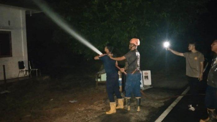 Upaya pemadaman dan pendinginan Gudang Arsip KPU Lingga oleh Damkar Lingga dibantu personel Kepolisian dan TNI, Rabu (11/12/2024) sore.