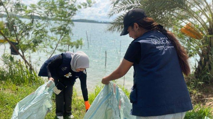 Karyawan HARRIS Barelang Batam antusias memungut sampah di pesisir Barelang dalam aksi peduli lingkungan Hari Bumi 2025.