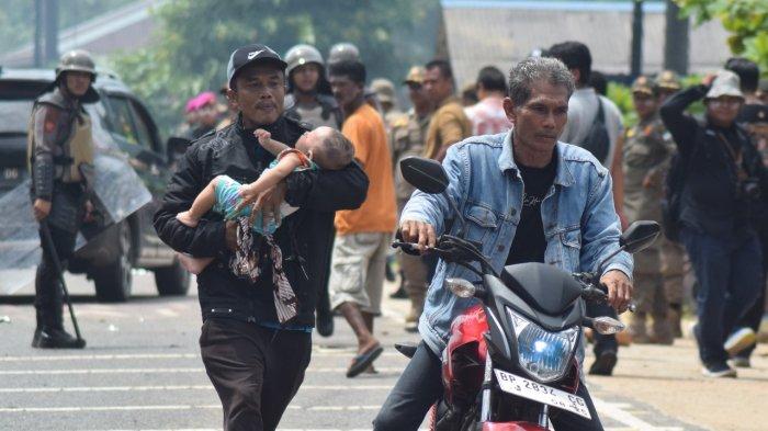 Herman ayah Algifari berlari mencari pertolongan ditengah bentrok warga dan Tim Terpadu di Rempang, Galang.
