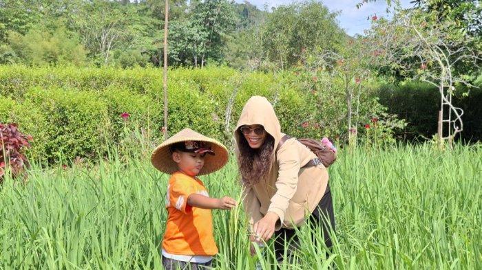 KAMPOENG SAWAH - Pengunjung wanita bersama anak laki-laki tengah berada di Kampoeng Sawah, Minggu (8/12/2024) siang.