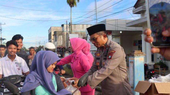 BAGI TAKJIL - Kapolres Natuna AKBP Nanang Budi Santosa dan Ketua Bhayangkari saat membagikan takjil kepada pengendara yang melintas di kawasan simpang tiga Puskesmas Ranai.