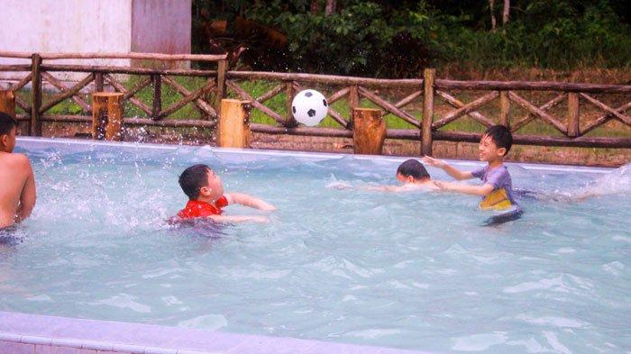 Dua anak di Lingga saat asyik bermain di Pemandian Air Panas Dabo Singkep, Kabupaten Lingga, Provinsi Kepulauan Riau (Kepri), Minggu (4/12/2022). Pemandian air panas di Lingga ini menjadi satu di antara destinasi wisata Kepri.