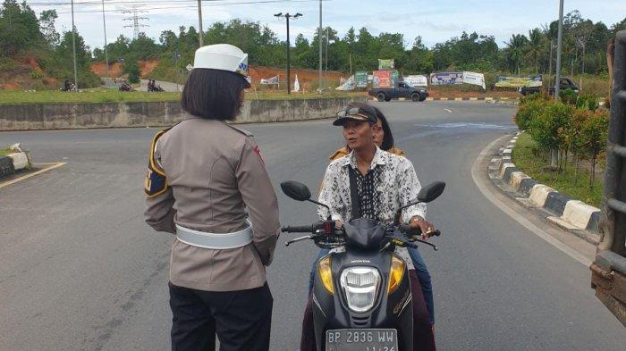 TILANG MANUAL DI BINTAN - Anggota Satlantas Polres Bintan saat berbincang dengan pengendara sepeda motor. Polres Bintan menerapkan tilang manual di Bintan sejak Mei 2023.