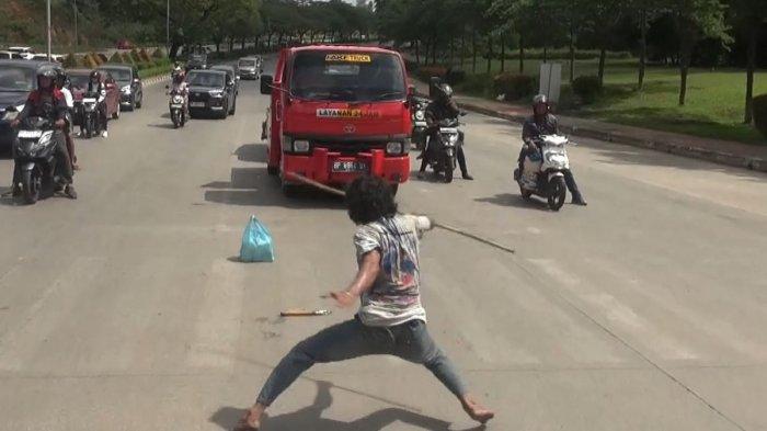 PENJUAL TISU DI BATAM VIRAL - Sudana Abdullah alias Cobra saat sedang beraksi memeragakan aksi silatnya di Simpang Laluan Madani, Kota Batam, Provinsi Kepulauan Riau (Kepri). Aksi yang sudah ia lakukan selama 8 bulan hingga viral di medsos ini membawa dampak baik pada usaha yang ia jalani.