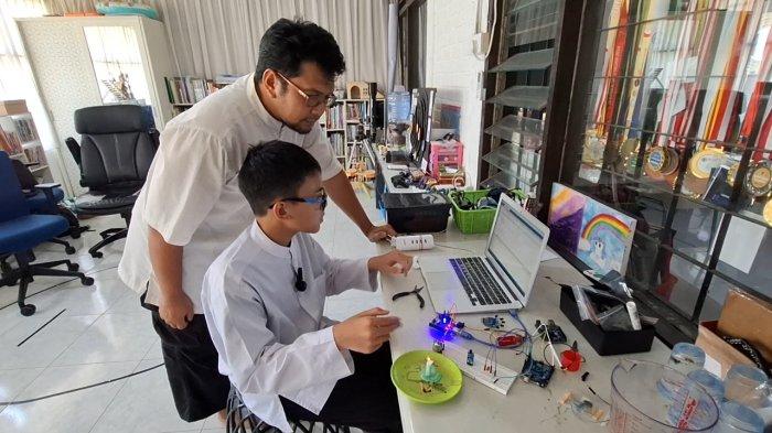 Reyyan bersama sang ayah, Dody Apriyanto saat melihat error yang terjadi di laptop