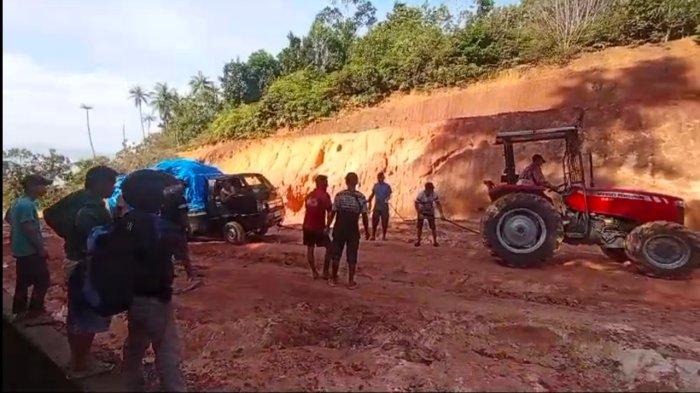 JALAN DI LINGGA RUSAK - Kondisi terjal jalan Pelabuhan Penarik di Kabupaten Lingga, Provinsi Kepulauan Riau (Kepri), Kamis (20/3/2025). Sopir angkutan sampai menyewa alat berat tarik mobil dan benahi jalan.