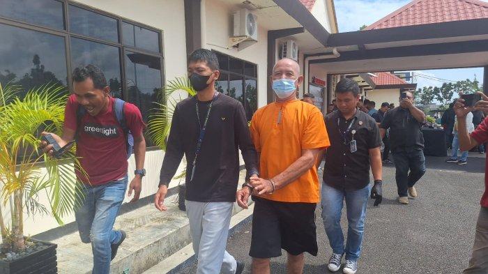 NARKOBA DI BINTAN - Lansia asal Batam bernama Fuad bin Hamdan digiring anggota Satresnarkoba Polres Bintan, Kamis (11/7/2024). Lansia 74 tahun itu terancam penjara seumur hidup setelah terbukti membawa sabu-sabu dan pil ekstasi dari Malaysia.