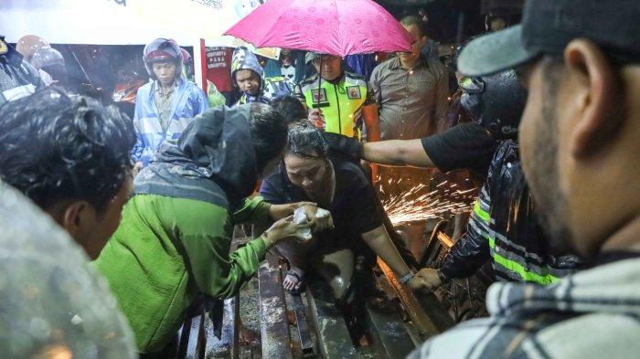 BANJIR DI BATAM - Kaki seorang wanita terjepit penutup drainase di area SPBU Batuampar saat banjir di Batam, Kamis (30/11).