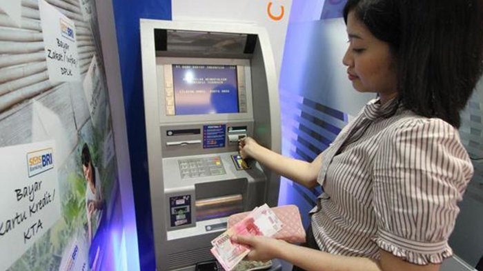 Nasabah Memeriksa Mesin ATM Sebelum Melakukan Transaksi