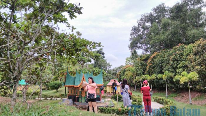 Warga berpose di depan Miniature House Indonesia di Golden Prawn.
