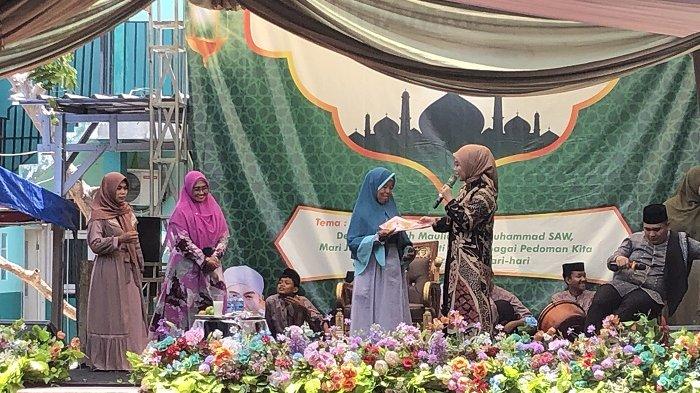 Calon Wakil Gubernur (Cawagub) Jawa Barat (Jabar) nomor urut 1, Gitalis Dwinatarina atau yang kerap disapa teh Gita KDI saat berbagi kerudung dengan ibu-ibu ketika acara maulid nabi di Yayasan Pendidikan dan Keterampilan (YPK) Patriot, Jalan Raya Sukatani, desa Sukadarma, kecamatan Sukatani, kabupaten Bekasi, Kamis (17/10/2024)