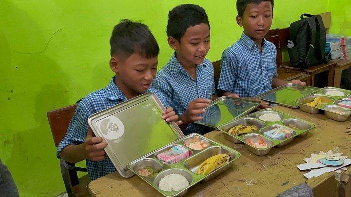 Murid SD Curug Kulon Tangerang sedang menikmati makan bergizi gratis (MBG).