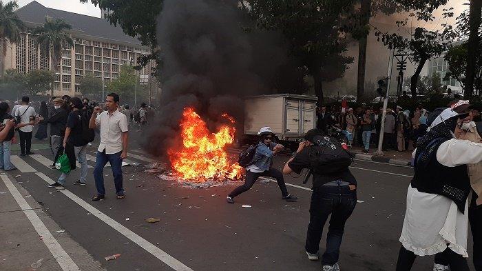Bubarkan diri, massa aksi tuntut hakim MK diskualifikasi Prabowo-Gibran sempatkan bakar ban di Kawasan Patung Kuda, Jumat (19/4/2024).
 
