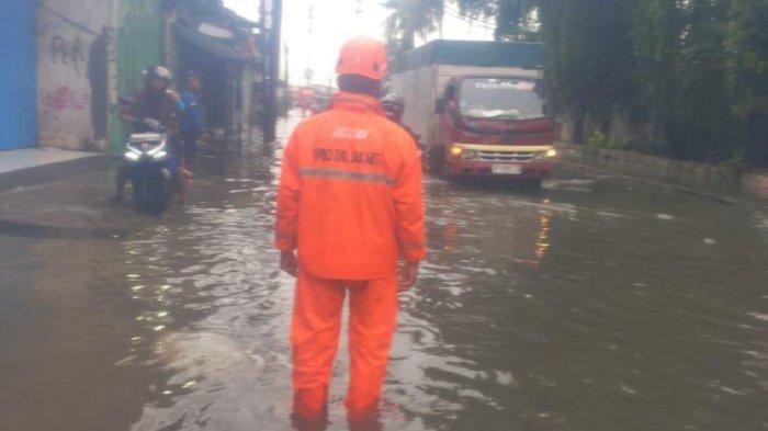 PANTAU BANJIR  --- Petugas BPBD memantau lokasi banjir di wilayah Cengkareng, Jakarta Barat, usai hujan deras yang mengguyur Sabtu (8/2/2025) dini hari.
