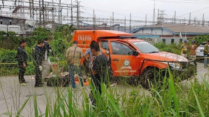 Sesosok mayat ditemukan dalam koper berwarna hitam yang tergelatak di pinggir Jalan Kalimalang, Desa Sukadanu, Kecamatan Cikarang Barat, Kabupaten Bekasi, Kamis (25/4/2024). Polisi langsung mendatangi tempat kejadian untuk mengidentifikasi korban.(KOMPAS.com/FIRDA JANATI)