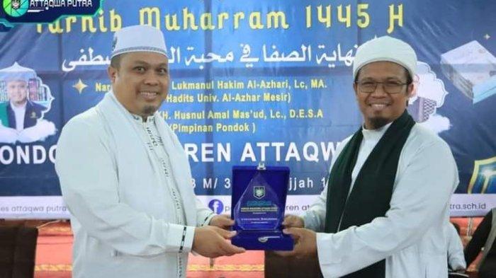 Penyerahan cinderamata Pimpinan Pondok Pesantren Attaqwa Putra KH. Husnul Amal kepada narasumber Dauroh Ilmiah  Dr. Lukmanul Hakim.