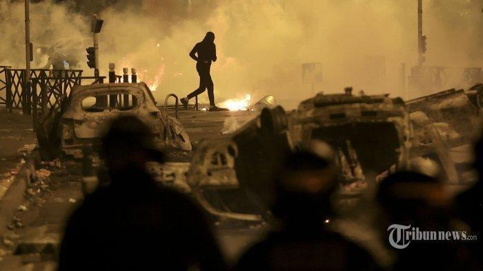 Seorang demonstran berlarian pada malam ketiga protes yang dipicu oleh penembakan fatal polisi terhadap seorang pengemudi berusia 17 tahun di pinggiran Paris Nanterre, Prancis, Jumat, 30 Juni 2023. Perusahaan media sosial kembali menjadi sorotan, ini waktu di Prancis ketika presiden negara itu menyalahkan TikTok, Snapchat, dan platform lain karena membantu memicu kerusuhan yang meluas atas penembakan polisi yang fatal terhadap seorang pengemudi berusia 17 tahun.