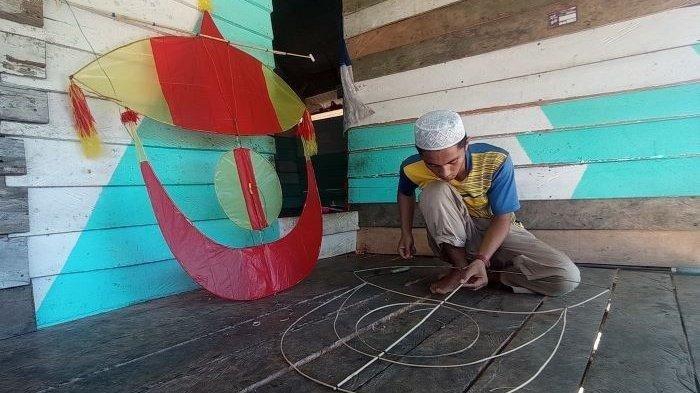 Jumadil (24)  saat membuat layang-layang goeng, di rumahnya jalan Kulan, Kampak, Tua Tunu, Kamis (10/8/2023).