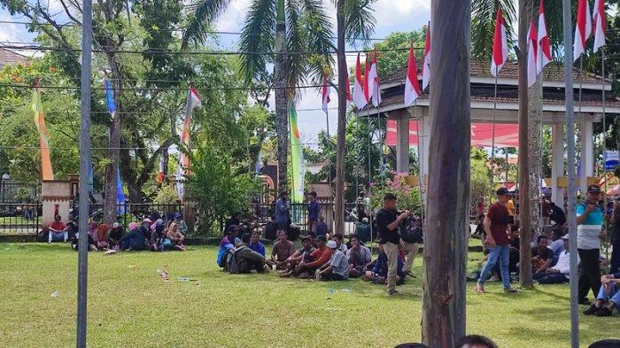 Massa pendemo menunggu kehadiran Bupati Belitung Sahani Saleh, dengan duduk-duduk di halaman kantor Bupati Belitung, Kamis (10/8/2023)