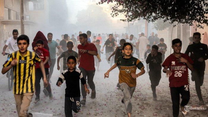Anak-anak Palestina berlarian saat mereka melarikan diri dari pemboman Israel di Rafah di Jalur Gaza selatan pada 6 November 2023, di tengah berlanjutnya pertempuran antara Israel dan kelompok militan Palestina Hamas. (Photo by Mohammed ABED / AFP)