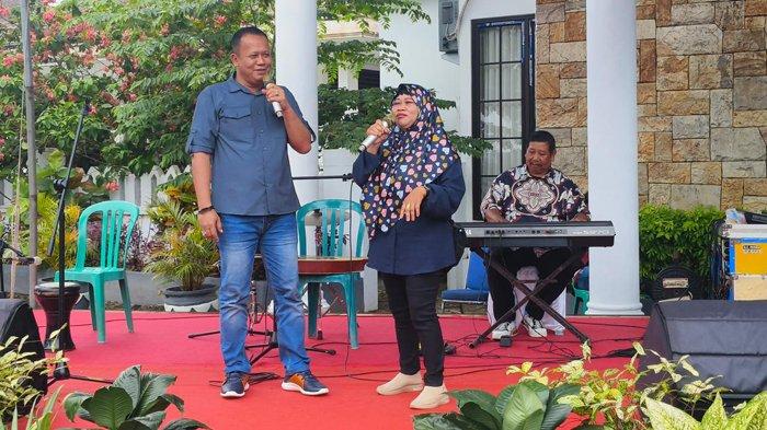 Pj Bupati Belitung, Mikron Antariksa, berduet dengan petugas kebersihan DLH Belitung bernama Ida Royani, saat kegiatan pemberian penghargaan untuk pettugas kebersihan di halaman Rumah Dinas Bupati Belitung, Sabtu (21/12/2024).
