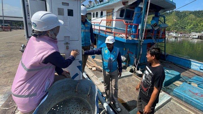 GUNAKAN ALMA -- Petugas PLN (kiri) ketika sedang berbincang dengan salah seorang pemilik kapal ikan, Hutagalung (kanan) yang sedang menggunakan ALMA saat kapalnya bersandar di Tempat Pelelangan Ikan (TPI) Kecamatan Sarudik, Kabupaten Tapanuli Tengah, Sumatera Utara.