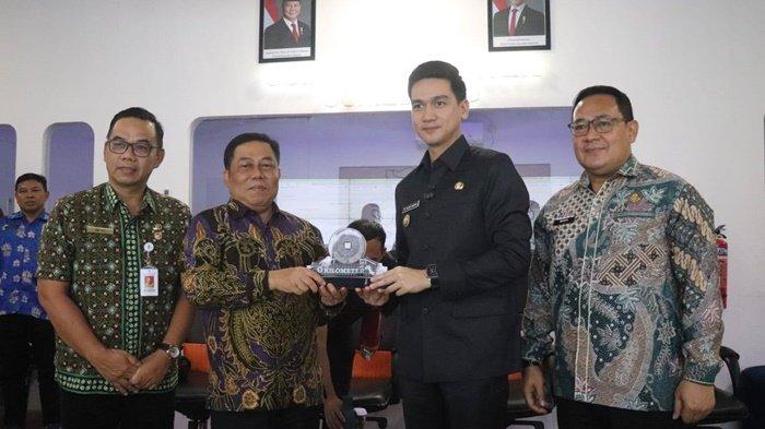 CENDERA MATA -- Penjabat Wali Kota Pangkalpinang, M. Unu Ibnudin, menyerahkan cendera mata kepada Wakil Bupati Sumedang, M. Fajar Aldila, usai pertemuan penjajakan kerja sama pengembangan Sistem Pemerintahan Berbasis Elektronik (SPBE) di Command Center Pemkab Sumedang, Jumat (16/5/2025).