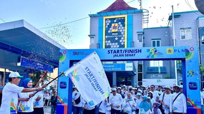 General Manager PLN UIW Babel, Dini Sulistyawati bersama suami mengangkat bendera start secara simbolis dimulainya jalan sehat ratusan kelurga besar PLN UIW Babel