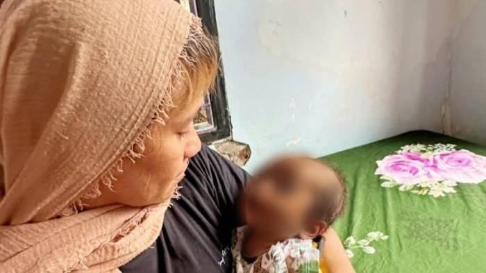 SUAMI BUNUH ISTRI - Kerabat dekat korban Mawar Yulia saat menggendong bayi korban dari pembunuhan suami bunuh istri di Dompu. Mawar mengungkapkan keinginannya untuk mengadopsi anak tersebut, meski belum secara resmi membicarakan niat itu kepada keluarga besar karena masih dalam masa berkabung