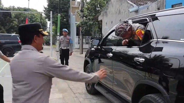 Aksi jenaka Kapolres Serang, AKBP Condro Sasongko saat hendak keluar dari mobil dinasnya.