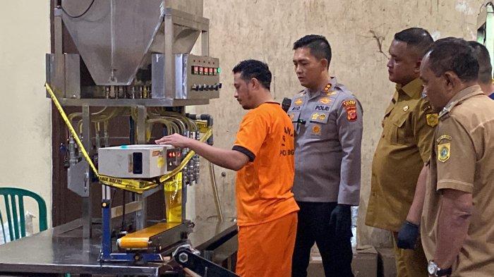 Pelaku peragakan pembuatan  MinyaKita palsu di wilayah Desa Cijujung, Kecamatan Sukaraja, Kabupaten Bogor, Senin (10/3/2025). (TribunnewsBogor.com/Muamaruddin Irfani)
 