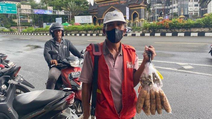 PEDAGANG DI GADOG - Yanto (55) pedagang asongan di jalur Puncak Bogor saat dijumpai di Simpang Gadog, Kecamatan Ciawi, Kabupaten Bogor, Rabu (29/1/2025). 