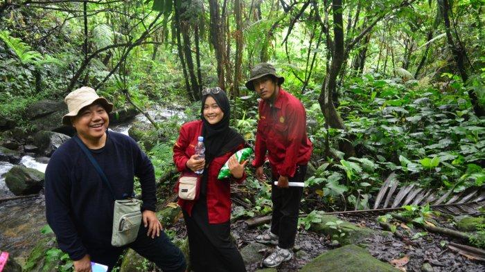 Jalur tracking menuju tempat wisata Curug Kembar Bogor dengan menyusuri hutan lembab dan aliran sungai.