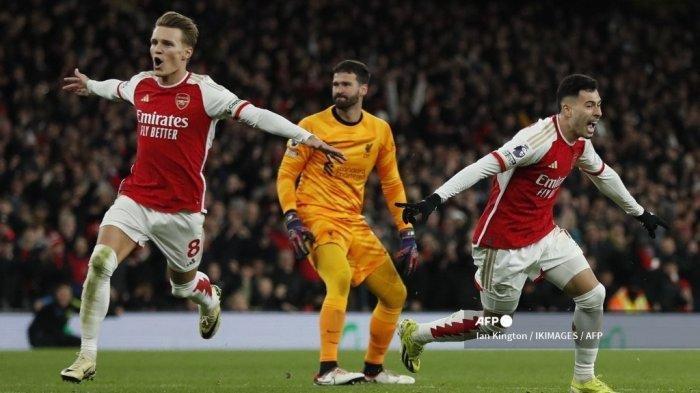 Gelandang Arsenal asal Brazil #11 Gabriel Martinelli (kanan) merayakan dengan gelandang Arsenal asal Norwegia #08 Martin Odegaard (kiri) di samping kiper Liverpool asal Brasil #01 Alisson Becker (tengah) setelah mencetak gol kedua timnya selama pertandingan sepak bola Liga Utama Inggris antara Arsenal dan Liverpool di Emirates Stadium di London pada 4 Februari 2024. (Tribunnews.com)