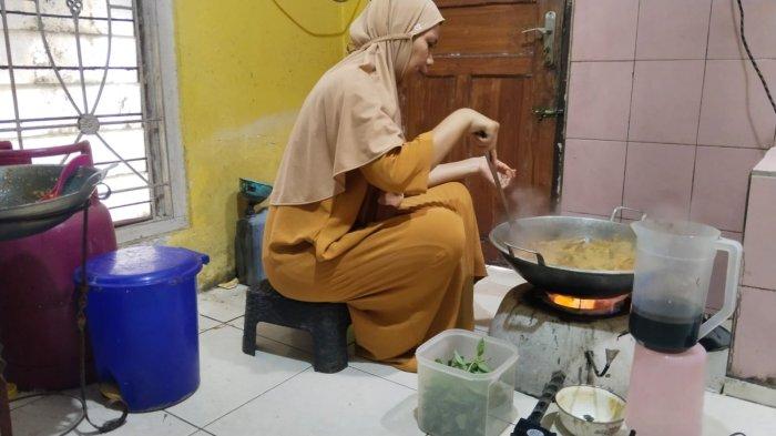 KOMPOR KUSTOM - Ine pengusaha kuliner di Desa Bandorasawetan, Kecamatan Cilimus, Kuningan, saat memasak, Jumat (7/2/2025). Ia menggunakan kompor kustom atau modifikasi untuk mengakali sulitnya mendapat gas melon.