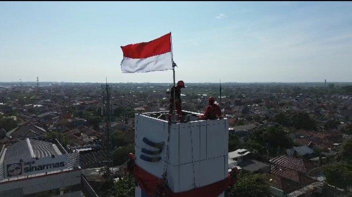 Pengibaran bendera raksasa di puncak menara Bank BJB Indramayu di Jalan Jenderal Sudirman Indramayu, Kamis (17/8/2023)