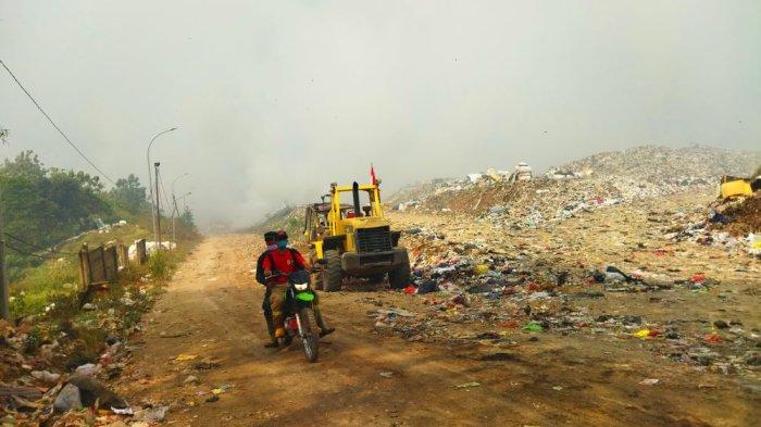 Petugas BPBD melintas di TPA Sarimukti yang saat ini diselimuti asap tebal