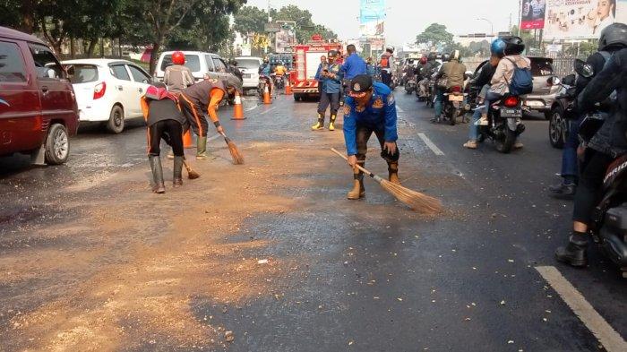 Petugas dari Diskar PB Kota Bandung membersihkan tumpahan oli di jalan Soekarno-Hatta, Kota Bandung, Senin (24/7/2023)
