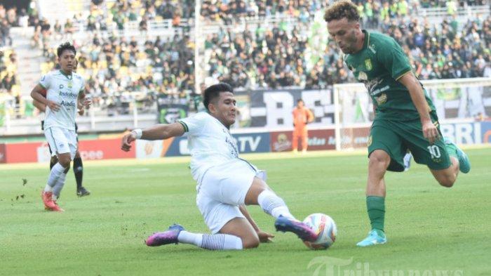 Bek Persib Bandung Putu Gede menggagalkan serangan Persebaya Surabaya.