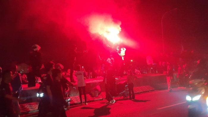 RAYAKAN JUARA - Sejumlah bobotoh saat berkonvoi dan menyalakan flare merayakan gelar juara Liga 1 yang diraih Persib Bandung di Flyover Pasupati, Kota Bandung, Senin (5/5/2025) malam.