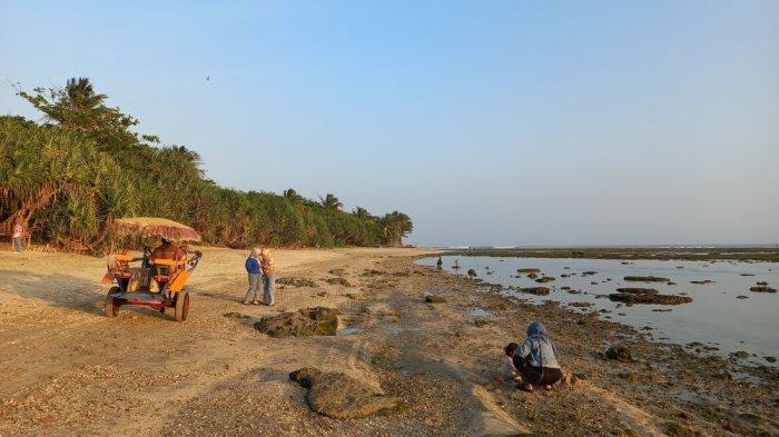 Sejumlah wisatawan nampak asyik berfoto dengan latar matahari terbenam di Pantai Minajaya.