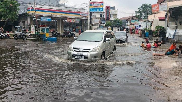 BANJIR DI TAMAN DUTA - Jalan Duta Pelni di depan pintu masuk Perumahan Taman Duta, Sukmajaya, Kota Depok terendam banjir, Senin (17/3/2025). (TribunnewsDepok.com/M Rifqi Ibnumasy)