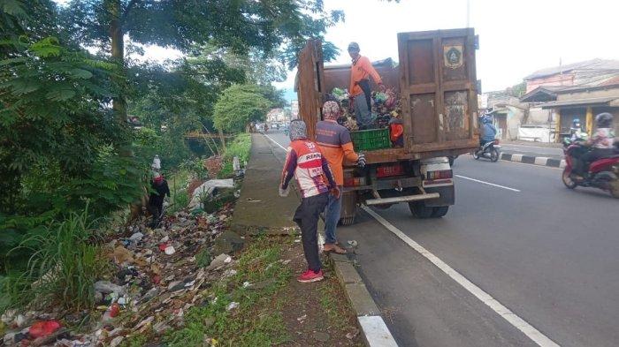 SAMPAH DI JALAN RAYA BOGOR - Petugas DLH Kabupaten Bogor membersihkan tumpukan sampah di sepanjang Jalan Raya Bogor, Kecamatan Sukaraja, Kabupaten Bogor, Jawa Barat, pada Selasa (20/5/2025).