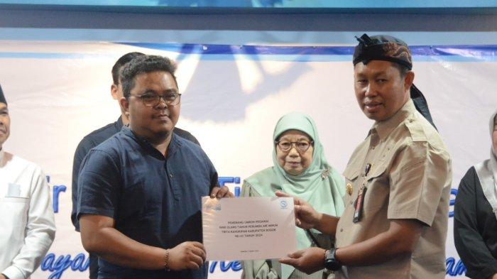 Pj. Bupati Bogor, Asmawa Tosepu (mengenakan topi khas Sunda Totopong) saat menghadiri acara tasyakuran HUT Perumda Tirta Kahuripan ke-43, di Aula Kantor Perumda Tirta Kahuripan, Cibinong, Selasa (5/3/2023). 