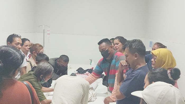 LIHAT - Suami Maria Mey, Albert Sollo (masker hitam) bersama keluarga lainnya sedang melihat jenazah Mey di ruang pemulasaraan jenazah Rumah sakit Leona Kota Kupang. 
