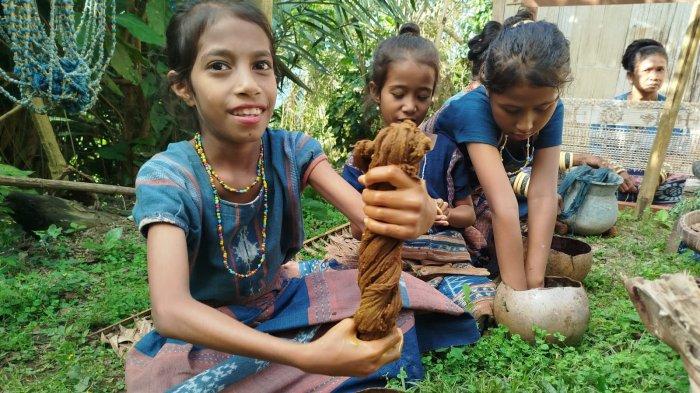 WARISAN BUDAYA- Seorang anak, anggota Sanggar Bliran Sina, sedang mengangkat benang yang telah dicelupkan pada cairan warna alam, Agustus 2024 lalu.