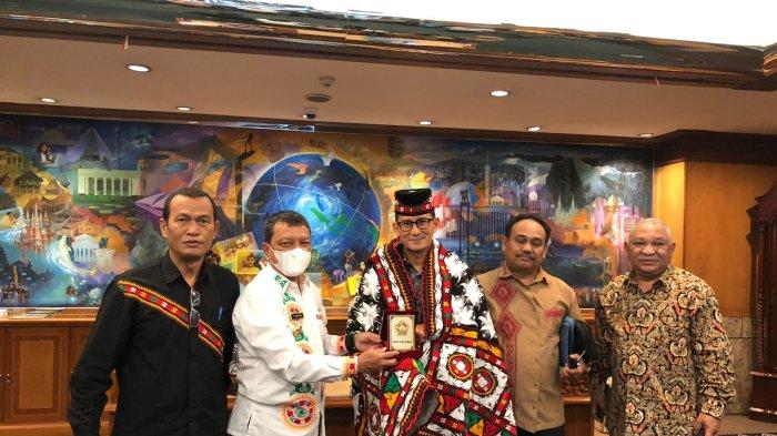 Pj Bupati Aceh Tengah memakaikan kain khas kerawang Gayo Upuh Ulen-ulen dan menyerahkan kopi Gayo ke Menteri Sandiaga Uno di Jakarta, Kamis (26/1/2023)
