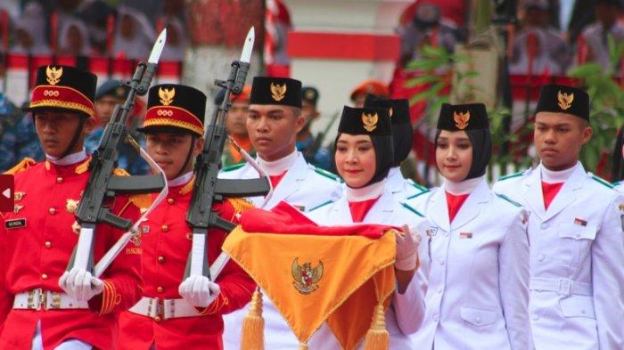 Suci tampak berjalan dengan tegap diapit oleh pasukan bersenjata menuju tiang bendera, Kamis (17/8/2023). FOTO: Wawan Akuba