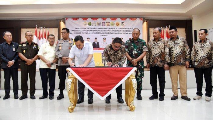 Penjagub Ismail Pakaya (kiri) bersama Ketua KPU Provinsi Gorontalo, Fadliyanto Koem, menandatangani NPHD untuk Pilkada 2024 di aula rumah jabatan gubernur, Selasa (24/10/2023). (Foto : Haris)